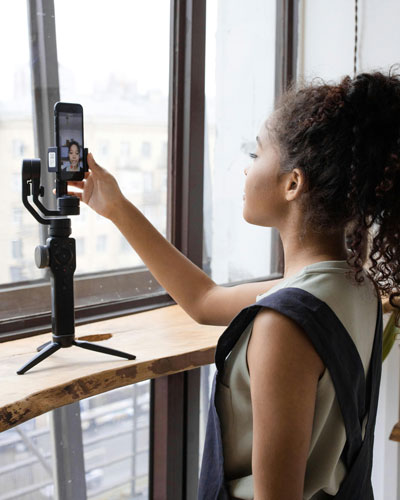 Eine Frau filmt sich selber im Selfie-Modus ihres Handys.